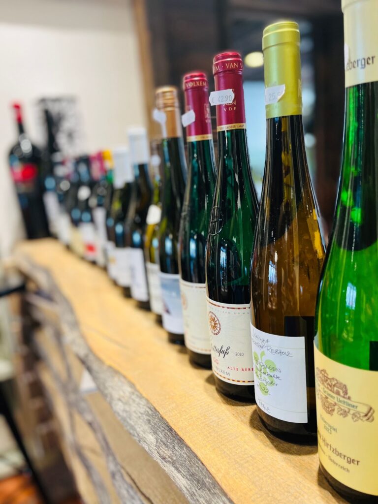 Weiß- und Rotweinflaschen aufgereiht auf einem Holzbrett im Miller Weinhaus