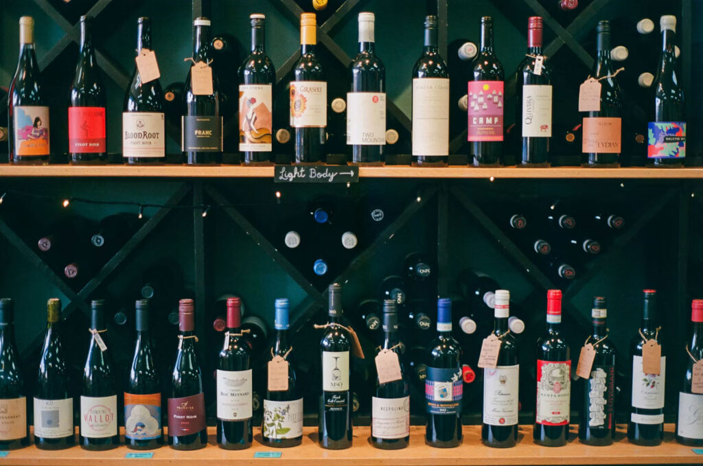 Weinwand im Miller Weinhaus mit zwei Regalreihen und handgeschriebenen Anhängern
